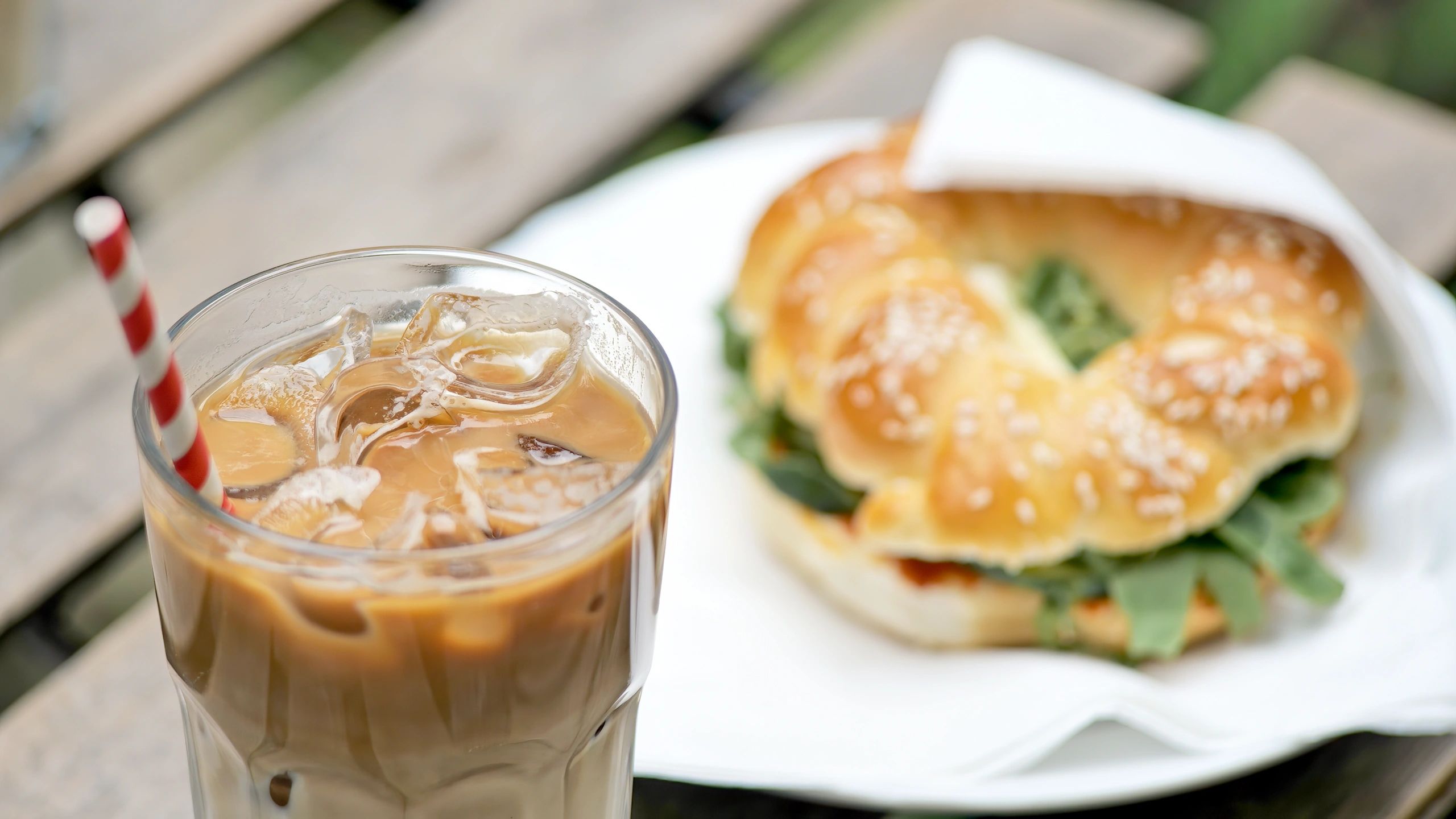 Iced coffee and a sandwich on a café table